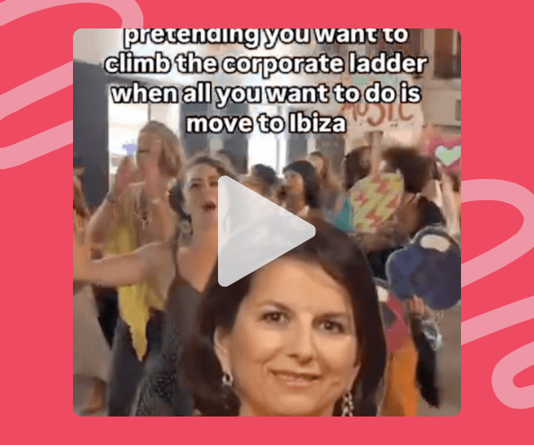 Screenshot of a video showing a woman in focus with a crowd dancing behind her, overlaid with the text: “pretending you want to climb the corporate ladder when all you want to do is move to Ibiza.” A play button icon is centered on the image.